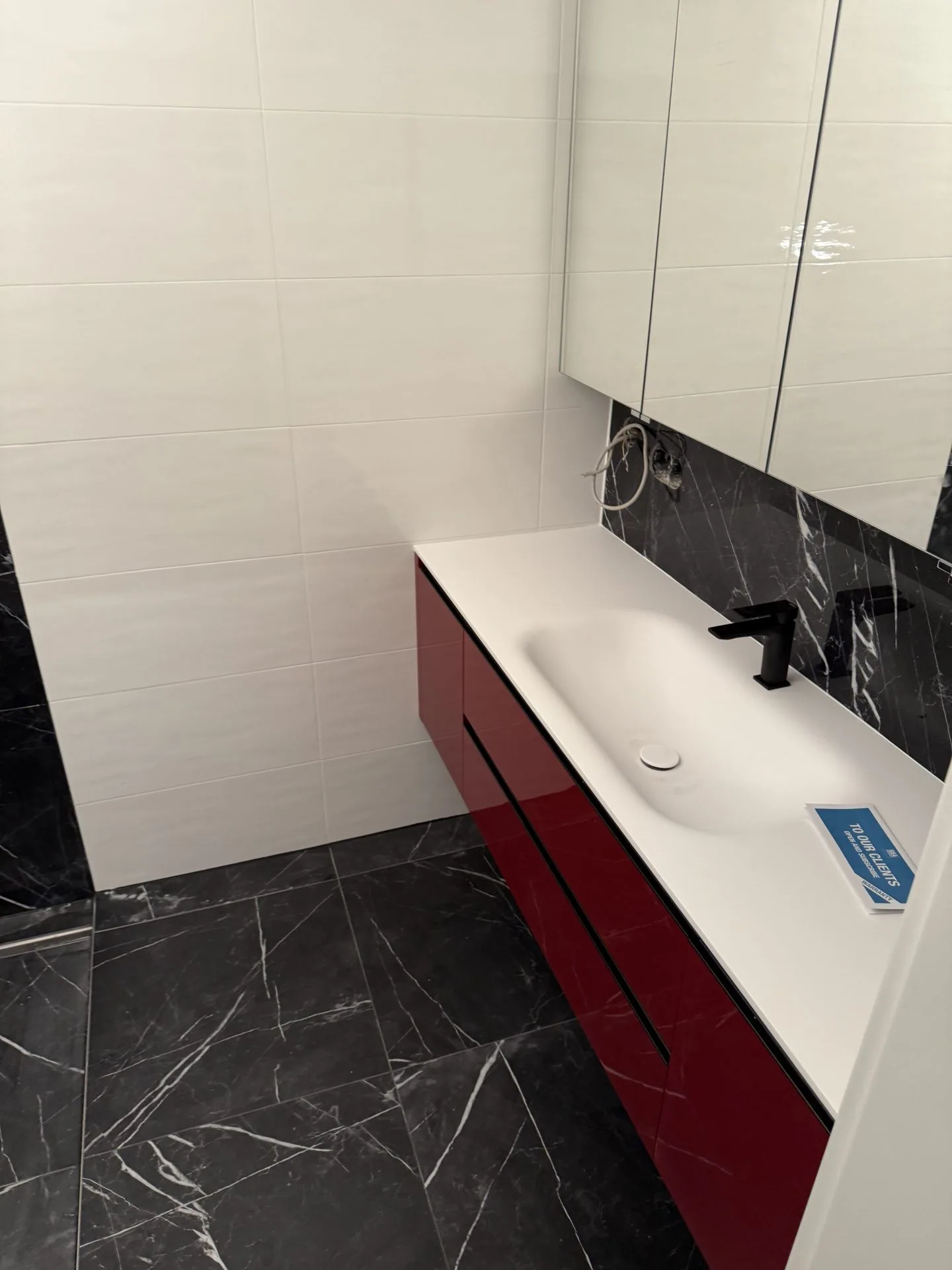 Bad mit dunklem Marmor und Bordeaux-Waschtisch, Graz